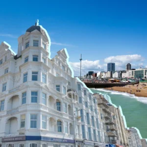 a beach with buildings and a body of water. Best Seafront Hotels In Brighton