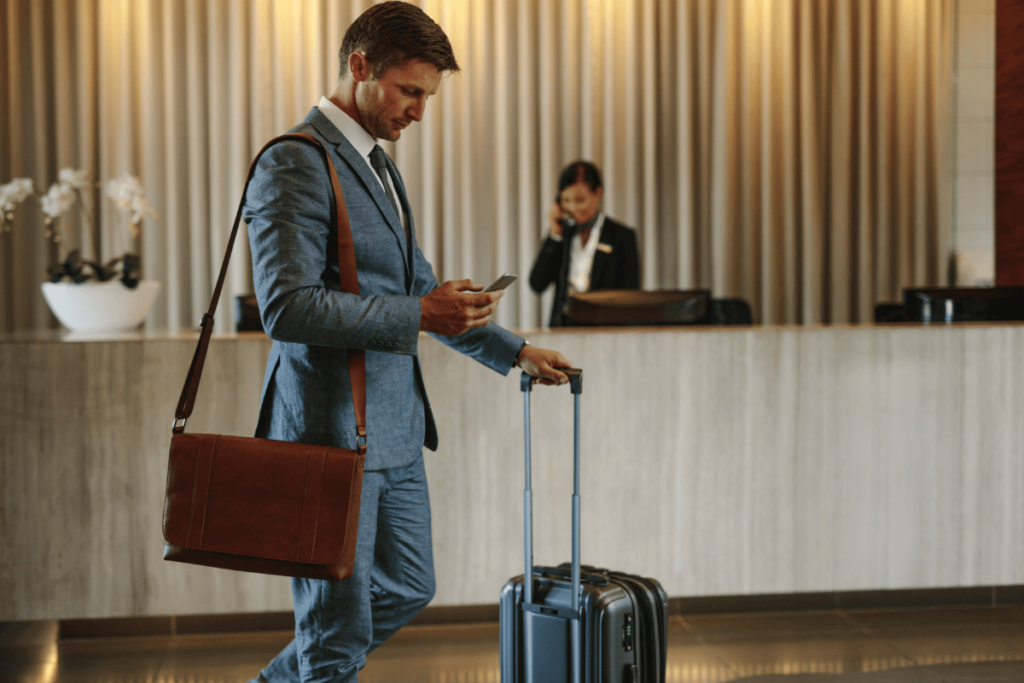 a man in a suit with a suitcase and a phone. How to choose the right hotel